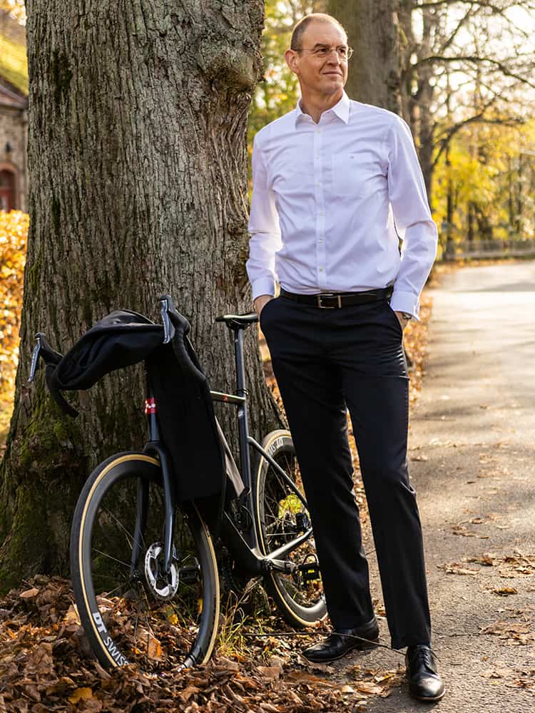 Stefan Baumann mit Rad lehnt an Baum